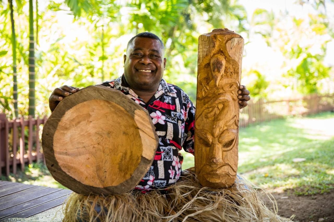 아우트리거 피지 비치 리조트 코로토고 외부 사진 A man from the Solomon Islands with a drum and a carved post